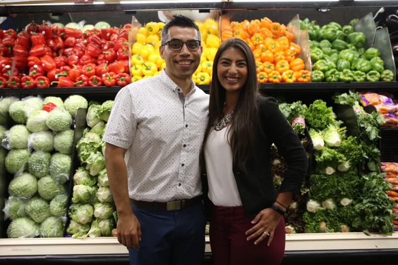 man and woman standing in produce aisle